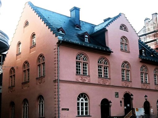 Altes Rathaus - Wiesbaden Rosa Fassade eines historischen Gebäudes mit Fenster und Dreiecksgiebel.