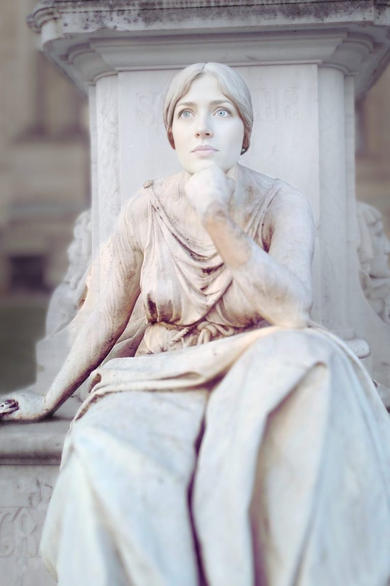 Eine sitzende Statue einer Frau in drapierter Kleidung, nachdenklich und elegant.